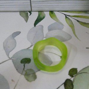 Green funky plastic ring. Has bumps in the middle. Modern.